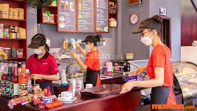 Nhân viên phục vụ tiếp đón khách hàng khi họ đến nhà hàng, dẫn họ đến bàn và cung cấp thực đơn