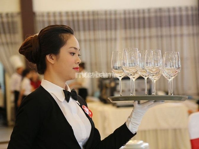 Nhân viên phục vụ mang nước cho khách