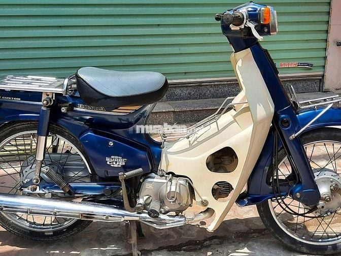  Mua bán xe Cub 82 cũ, chính chủ, giá tốt T6/2025 Xe Cub 82 là một trong những dòng xe huyền thoại của Honda, đã gắn liền với cuộc sống của người dân Việt Nam từ những năm 1980. Với thiết kế đặc trưng và động cơ bền bỉ, Cub 82 không chỉ đơn thuần là một phương tiện di chuyển, mà còn trở thành biểu tượng của sự bền bỉ và tiết kiệm. Nếu bạn cũng đang quan tâm đến dòng xe này, hãy tham khảo các thông tin hữu ích mà Muaban.net chia sẻ bên dưới! Mua bán xe Cub 82 Nhật cũ giá tốt, chất lượng 1. Bảng giá mua bán xe Cub 82 cập nhật T6/2025 Trên thị trường xe máy cũ hiện nay, Cub 82 đang được rao bán với mức giá từ 6 - 55 triệu đồng. Tùy theo mỗi phiên bản, tình trạng xe, năm và nơi sản xuất, động cơ, khu vực mua bán… mà giá bán sẽ khác nhau. Sau đây là bảng giá một số dòng xe Cub 82 cũ mà bạn có thể tham khảo: Phiên bản Cub 82 Giá bán tham khảo Cub 82 50cc 6 - 15 triệu đồng Cub 82 70cc 7 - 55 triệu đồng Cub 82 90cc 7 - 50 triệu đồng Lưu ý: Bảng giá mua bán xe Cub 82 Nhật zin cũ trên chỉ mang tính chất tham khảo. Để biết giá chính xác nhất theo từng tình trạng xe, hãy truy cập Muaban.net tham khảo các tin đăng ngay! 2. Giới thiệu tổng quan về mẫu xe Cub 82 Cub 82 - một trong những dòng xe cũ được nhiều người yêu thích và lựa chọn mua. Với thiết kế cổ điển và động cơ tiết kiệm nhiên liệu, Cub 82 vẫn là chiếc xe cũ đáng tin cậy trong việc di chuyển hàng ngày. 2.1. Thiết kế Cub 82 nổi bật với thiết kế đơn giản nhưng mang đậm phong cách cổ điển. Xe có phần đèn pha vuông vắn đặc trưng, kết hợp với đèn xi nhan chữ nhật và các chi tiết vuông trên thân xe, tạo nên vẻ ngoài mạnh mẽ, nam tính. Cub 82 có thiết kế đơn giản nhưng mang đậm phong cách cổ điển Xe Cub 82 thường có nhiều lựa chọn màu sắc, bao gồm xanh lam, trắng, đen, đỏ và xanh lá, đáp ứng nhu cầu đa dạng của người dùng. Đường cong nhẹ nhàng ở yếm xe, cốp xe, và yên trước giúp mang lại sự mềm mại, cân đối với các khối vuông vắn khác trên xe. Mặt đồng hồ của xe được thiết kế đơn giản, hiển thị các thông tin cơ bản như tốc độ, mức xăng, đèn báo số và xi nhan, phù hợp với phong cách cổ điển của xe. 2.2. Động cơ vận hành Xe Cub 82 sử dụng động cơ 4 thì, dung tích 50cc/70cc/90cc, nổi bật với tính năng tiết kiệm nhiên liệu và bền bỉ. Động cơ này cho phép xe vận hành một cách êm ái và ổn định, đặc biệt phù hợp cho việc di chuyển trong đô thị với tốc độ thấp. Với hộp số 3 cấp, Cub 82 dễ dàng điều khiển, ngay cả với những người mới lái xe. Xe Cub 82 sử dụng động cơ 4 thì, dung tích 50cc Mặc dù không thể đạt tốc độ cao, Cub 82 lại ghi điểm với khả năng tiết kiệm nhiên liệu, chỉ tiêu thụ khoảng 1,5 lít xăng cho 100km di chuyển, giúp người dùng tiết kiệm chi phí vận hành. Đặc biệt, xe được trang bị hệ thống giảm xóc trước và sau cùng hệ thống phanh cơ an toàn, đảm bảo trải nghiệm lái xe êm ái, an toàn cho người dùng. 3. Ưu và nhược điểm xe Cub 82 Dưới đây là một số điểm mạnh và điểm yếu của xe Honda Cub 82 cũ mà bạn nên tham khảo trước khi quyết định chọn mua: 3.1. Ưu điểm Được biết đến như một biểu tượng của sự bền bỉ và tiện lợi, xe Cub 82 không chỉ mang lại trải nghiệm lái mượt mà, dễ sử dụng, mà còn tiết kiệm nhiên liệu và chi phí cho người dùng. Dưới đây là những ưu điểm nổi bật của xe Cub 82: Giá bán hợp lý: Cub 82 cũ có mức giá bán khá phải chăng chỉ từ 6 - 15 triệu đồng, đây là mức giá khá rẻ. Riêng chỉ với các dòng xe khan hiếm trên thị trường thì mới có mức giá cao, có thể lên đến 50 triệu đồng. Tiết kiệm nhiên liệu: Xe Cub 82 nổi bật với khả năng tiết kiệm nhiên liệu, chỉ tiêu tốn khoảng 1,7 lít xăng cho 100km di chuyển trong thành phố. Khả năng tải trọng tốt: Xe có thể chở khối lượng lớn, phù hợp cho việc vận chuyển nông sản, gia súc, gia cầm, hoặc hàng hóa gia đình ở các nước đang phát triển. Động cơ bền bỉ: Xe trang bị động cơ 4 thì tiên tiến của Nhật Bản, hoạt động mạnh mẽ và thân thiện với môi trường. Phụ tùng dễ tìm, giá rẻ: Phụ tùng của Cub 82 dễ mua và có giá cả phải chăng, với nhiều lựa chọn từ đồ Nhật đến sản phẩm sản xuất tại Việt Nam. Ưu điểm khi chọn mua xe Cub 82 Nhật đã qua sử dụng 3.2. Nhược điểm Mặc dù có nhiều ưu điểm, nhưng xe Cub 82 vẫn tồn tại một số nhược điểm có thể ảnh hưởng đến trải nghiệm của người dùng. Dưới đây là những điểm hạn chế của dòng xe này: Khó tăng tốc: Nhược điểm lớn nhất của xe Cub 82 là khó tăng tốc lên 50km/h. Do đó, xe chỉ phù hợp với nhu cầu di chuyển hàng ngày. Còn nếu bạn muốn tốc độ nhanh hơn thì nên chọn các dòng xe như Wave, Sirius… Yên sau không thoải mái: Yên sau của xe được thiết kế vuông vức từ kim loại với khe hở và không có lớp đệm, làm cho người ngồi sau cảm thấy không thoải mái trong các chuyến đi dài. Nhược điểm khi chọn mua xe Cub 82 cũ 4. Kinh nghiệm khi mua xe Cub 82 cũ Để tìm mua được chiếc xe Cub 82 cũ chất lượng, uy tín, giá tốt. Bạn nên bỏ túi một số kinh nghiệm mua xe máy cũ hữu ích mà Muaban.net chia sẻ dưới đây: 4.1. Xác định nhu cầu tài chính Trước khi tìm mua, hãy xác định ngân sách mà bạn sẵn sàng chi trả cho chiếc xe Cub 82 cũ. Điều này giúp bạn thu hẹp phạm vi tìm kiếm và tập trung vào những chiếc xe phù hợp với khả năng tài chính của mình. Đừng quên tính toán các chi phí phát sinh khác như phí bảo dưỡng, thay thế phụ tùng, hoặc cải tiến nếu cần thiết. Việc có một ngân sách rõ ràng sẽ giúp bạn tránh được việc mua phải xe với giá quá cao hoặc không hợp lý với giá trị thực tế. 4.2. Tìm mua xe tại các nguồn uy tín Khi tìm mua xe, bạn hãy chọn các địa điểm uy tín để đảm bảo mua được chiếc xe Cub 82 cũ, chất lượng với giá tốt. Bên cạnh mua tại cửa hàng xe máy cũ, qua giới thiệu của bạn bè, người thân hay trên các hội nhóm facebook, zalo… Thì bạn cũng có thể tìm mua trên các website rao vặt trực tuyến như Muaban.net. Tìm mua xe Honda Cub 82 đã qua sử dụng tại các nguồn uy tín Muaban.net là một trong những website chuyên về đăng tin mua bán xe máy, ô tô cũ uy tín. Với lượng tin đăng phong phú, cập nhật thường xuyên và giao diện dễ sử dụng, Muaban.net giúp người mua tìm kiếm chiếc xe phù hợp một cách nhanh chóng. Hơn nữa, trang web còn có kiểm duyệt thông tin người bán và sản phẩm, giảm thiểu rủi ro mua phải xe không chất lượng hoặc gặp phải các trường hợp lừa đảo. 4.3. Kiểm tra kỹ tình trạng xe Hãy kiểm tra tình trạng của xe một cách kỹ lưỡng từ trong ra ngoài để đảm bảo mua được chiếc xe cũ chất lượng. Dưới đây là những điểm quan trọng cần lưu ý trong quá trình kiểm tra: Khung sườn và thân xe: Xem xét kỹ khung sườn và thân xe để phát hiện dấu hiệu rỉ sét, vết nứt hoặc biến dạng. Đồng thời, kiểm tra lớp sơn để đảm bảo không có trầy xước hoặc dấu hiệu sơn lại. Động cơ và hệ thống phanh: Khởi động động cơ và lắng nghe âm thanh để đảm bảo động cơ hoạt động mượt mà và không phát ra tiếng kêu lạ. Kiểm tra mức dầu động cơ và tình trạng hệ thống phanh, bao gồm độ mòn của đĩa phanh và phản hồi khi phanh. Bánh xe, lốp, hệ thống đèn và đồng hồ: Kiểm tra lốp và vành bánh xe để phát hiện dấu hiệu hỏng hóc. Đảm bảo tất cả các đèn chiếu sáng hoạt động bình thường và kiểm tra đồng hồ để đảm bảo các chỉ số hoạt động chính xác. Kiểm tra kỹ lưỡng toàn bộ tình trạng của xe trước khi chọn chọn mua 4.4. Chạy thử xe và đánh giá lần cuối Sau khi kiểm tra tình trạng xe, bước cuối cùng không thể thiếu là chạy thử xe. Lái xe ở nhiều tốc độ khác nhau để kiểm tra khả năng tăng tốc, cảm giác lái và độ ổn định của xe. Chú ý đến cách xe phản ứng với các thao tác phanh và việc điều khiển, cũng như lắng nghe động cơ để phát hiện bất kỳ tiếng ồn bất thường nào. Chạy thử xe giúp bạn có cái nhìn thực tế hơn về hiệu suất và chất lượng của xe, từ đó đưa ra quyết định mua xe một cách tự tin và chính xác. Lưu ý khi mua xe Honda Cub 82 đã qua sử dụng Lời kết Bài viết đã chia sẻ đến bạn giá bán xe Cub 82 cũ cùng ưu, nhược điểm và kinh nghiệm khi chọn mua dòng xe này. Hy vọng với những thông tin hữu ích trên, bạn sẽ có sự chuẩn bị tốt nhất và đưa ra quyết định sáng suốt khi mua xe máy đã qua sử dụng. Đừng quên truy cập Muaban.net mỗi ngày để không bỏ lỡ các tin đăng mới nhất về mua bán xe Cub nói riêng và các dòng xe máy Honda cũ trên toàn quốc nhé!